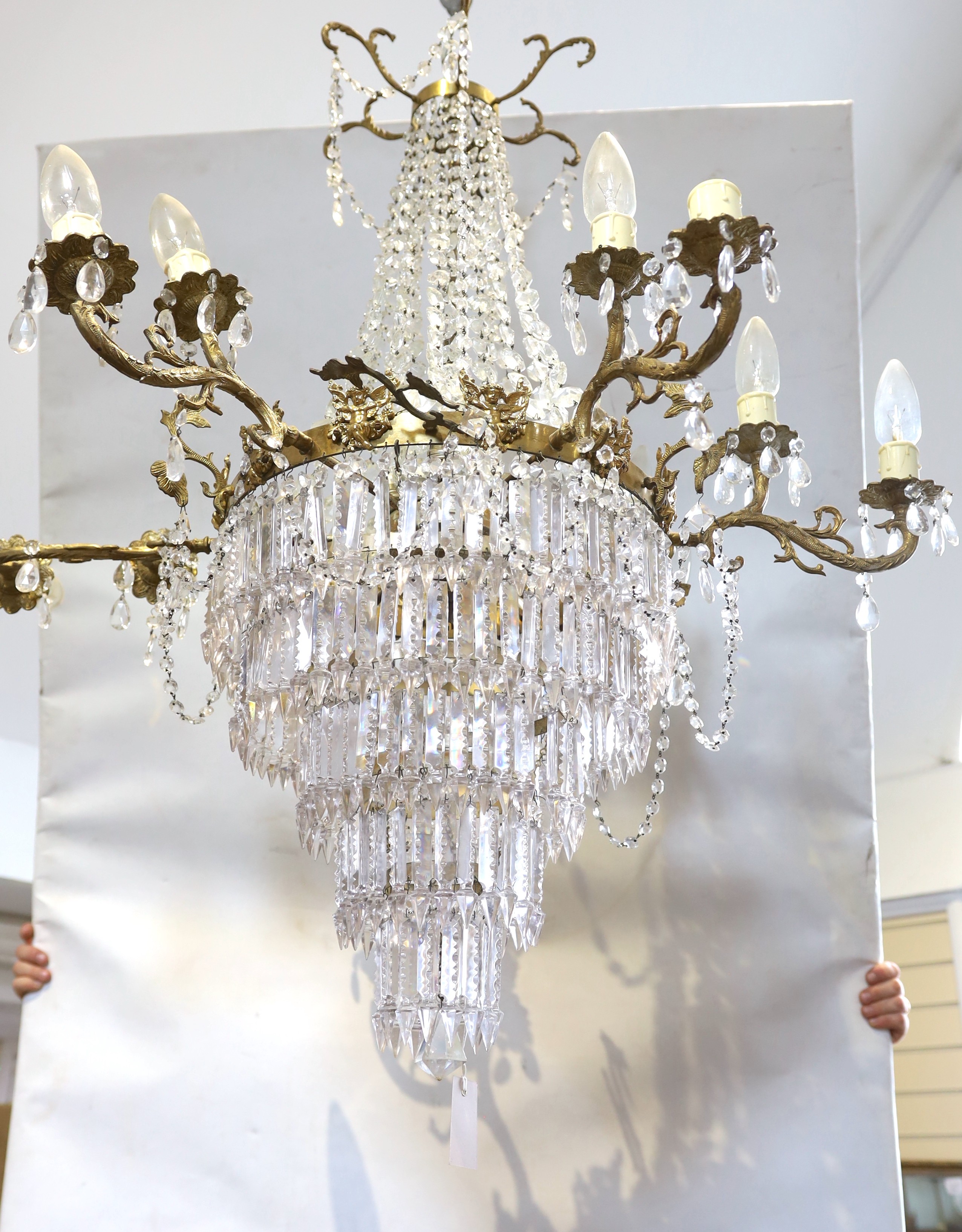 A mid 20th century brass thirteen light electrolier of circular tapered form hung faceted bead, pear and spear drops. Height appropriately 120cms